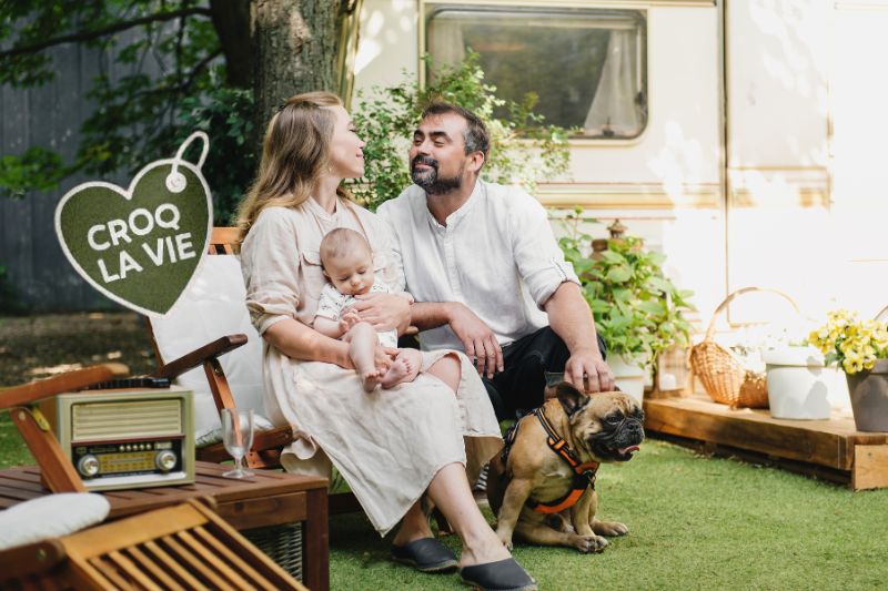 Famille dans leur jardin avec leur chien contents ayant résolu les problèmes de diarrhée jaune depuis qu'il mange les croquettes CROQ' la Vie