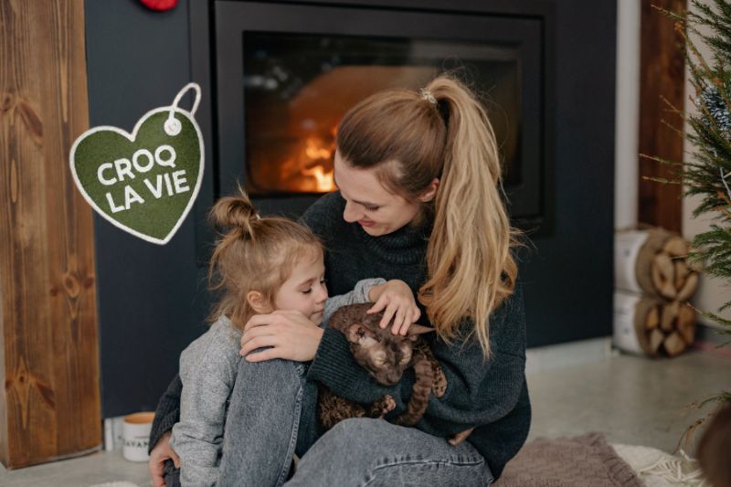 Mère et fille avec leur chat dans les bras heureux ayant résolu les problèmes d'infection urinaire de son chat depuis qu'il mange les croquettes CROQ' la Vie